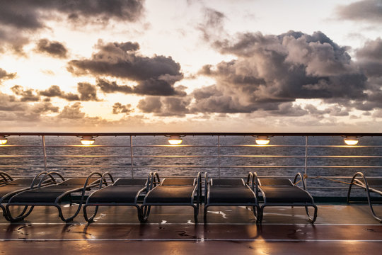 Sunbeds on cruise ship with cloudy sky