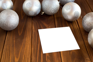 Christmas balls, toys on the Christmas tree silver on a brown wooden background
