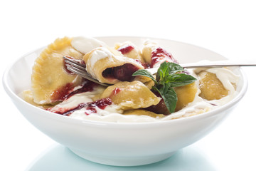 Homemade sweet dumplings with berries and sour cream