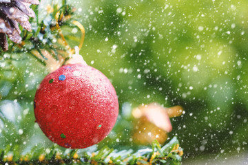 Obraz premium Red Christmas ball decoration hanging on tree with snow effect