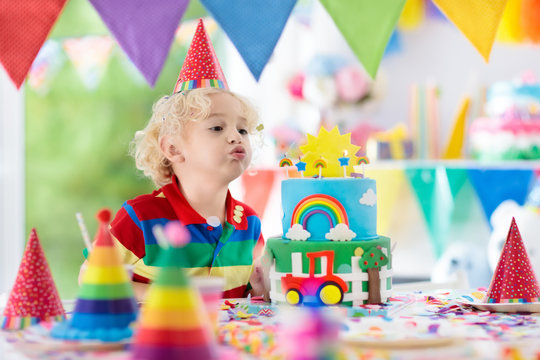 Kids birthday party. Child blowing out cake candle