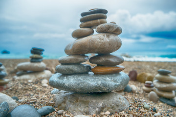 Fototapeta na wymiar Pyramid of sea pebbles on the sea background