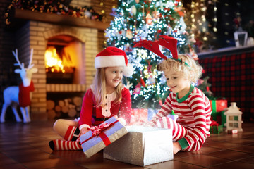 Obraz na płótnie Canvas Child at Christmas tree. Kids at fireplace on Xmas