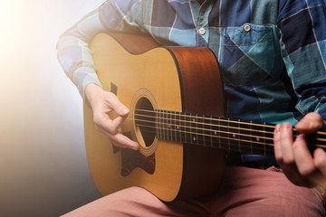 Fototapeta premium Musican with guitar in hand on dark background. Studio shot