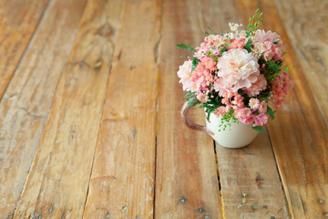 Artificial flowers on the wooden vintage background. Selective focus.