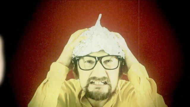 Fake 8mm amateur film: an angry man wearing a tin foil aluminium hat (believing that it shields the brain from threats such as electromagnetic fields, mind control or reading).
