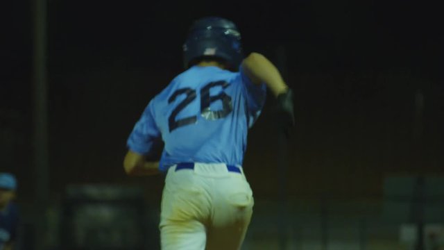 Slow Motion of baseball player batting and running to first base at game