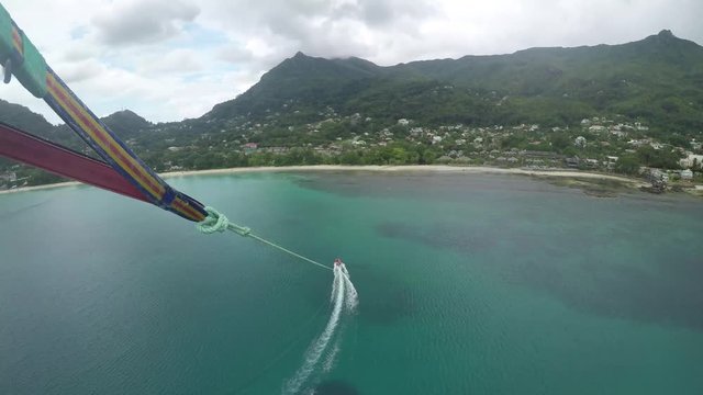 An adventurous couple parasailing at Beau Vallon Beach in Mah_, Seychelles. GoPro, extreme summer sports, POV.  onboard camera. , 1 of 3