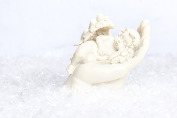 Angel resting in the loving hand of maria in a snow setting