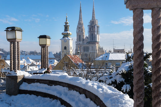 View over Zagreb during winter with snow with view to towers of church and cathedral and seating area with laternsat a sunny day, Zagreb, Croatia, Europe