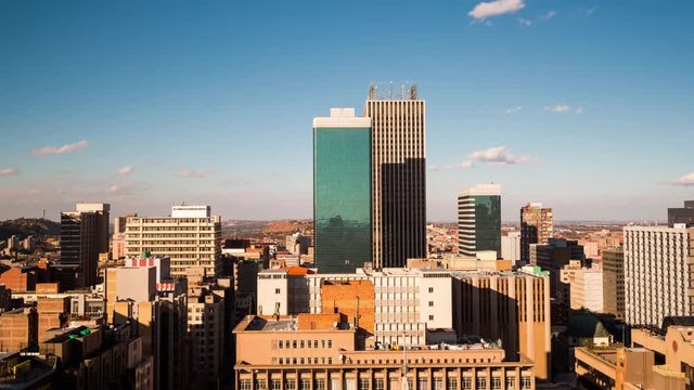 A slow tilt-up timelapse across the city centre of Johannesburg (CBD) in the daytime with bright blue skies and cumulous clouds showing the High Court(Johannesburg, Gauteng, South Africa