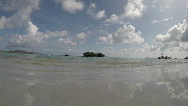 GoPro timelapse on Cote DÍor beach, Praslin with boats and catamarans on the ocean with Chauve Souris while waves crash in the foreground. POV.   