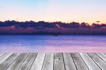 Fototapeta na wymiar wooden floor terrace or plank desk with beautiful twilight sky on the sea at sunset background, copy space for display of product or object presentation