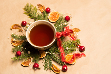 Cup of black tea, Christmas toys, gifts and decorations on craft background