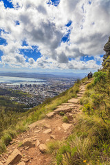 Fototapeta premium Aufnahme von Kapstadt vom Aufstiegsweg zum Lions Head tagsüber bei bleuem Himmel mit weißen Wolken fotografiert in Südafrika im September 2013