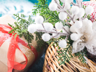 Wicker basket full of Christmas decorations. Gift box and snow
