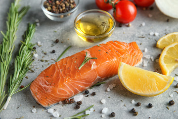Slice of salmon fillet and ingredients for marinade on table