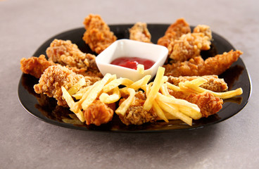potatoes and wings with sauce in the plate on the table