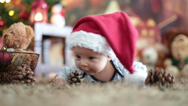 Portrait of newborn baby in Santa clothes, winter snow landscape outdoor