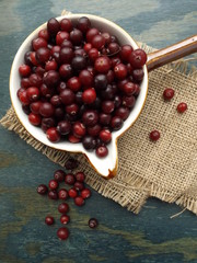 Cranberries in a ceramic sauceboat on sacking.