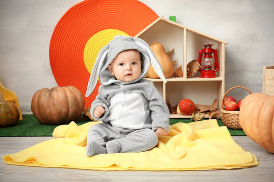 Adorable baby in bunny costume indoors