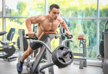 Naklejka na ściany i meble Muscular man training in gym