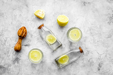 Obraz na płótnie Canvas Fresh homemade lemonade. Lemons, juicer, glass for beverage on grey stone background top view copyspace