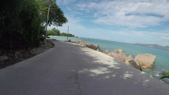 Go Pro point of view from a tourist bicycle while cycling around the island of Ladigue, Seychelles next to the ocean. POV.  