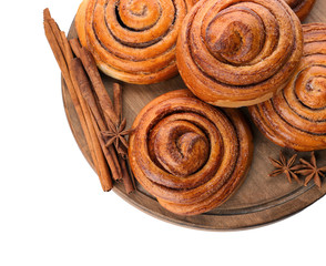 Wooden board with sweet cinnamon rolls on white background