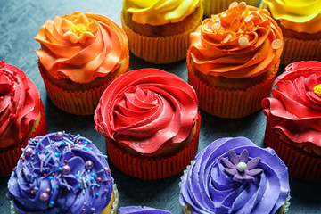 Tasty colorful cupcakes on table