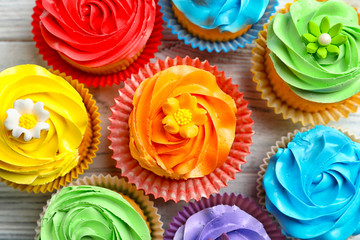 Tasty colorful cupcakes on table