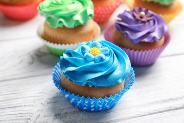 Tasty colorful cupcakes on wooden table