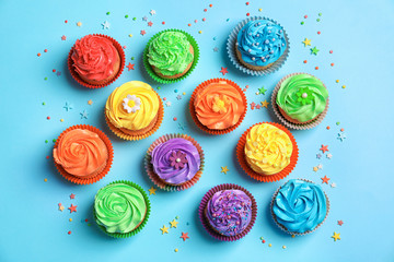 Tasty cupcakes on color background