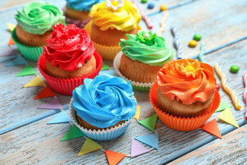 Tasty colorful cupcakes on wooden table