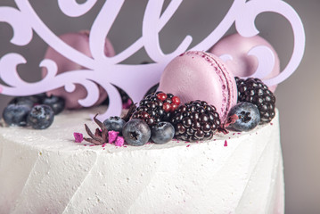 Obraz na płótnie Canvas Beautiful delicious three-tiered wedding cake decorated with berries blueberry and blackberries in pink purple color