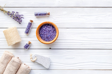Set for foot spa with lavender. Flowers, spa salt, pumice stone, soap on white wooden background top view copyspace