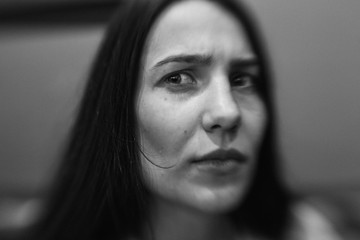 Style girl sitting on the sofa in the cafe. Photo in black and white style.