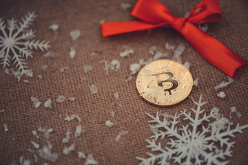 Gold bitcoin. Crypto currency bitcoin on a Christmas background red bow and snowflakes. problems and business growth. New Year's warm tinting