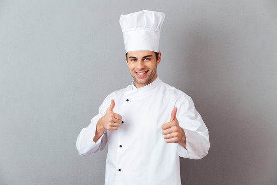 Smiling emotional young cook with thumbs up.