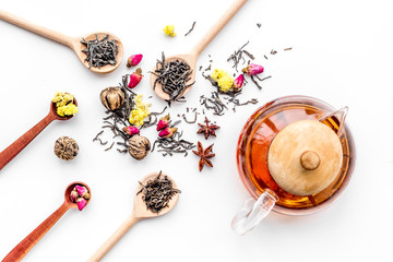 Brew tea with flowers and spices. Dried leaves and petals near tea pot on white background top view pattern