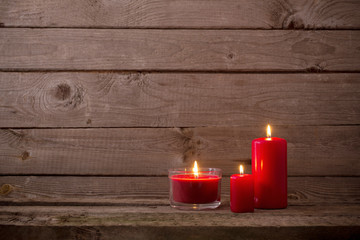 Fototapeta na wymiar red candles on dark wooden background