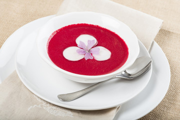 Sopa fría o gazpacho de remolacha rábano cebolla morada y tomate para una comida sana o vegetariana decorada con flor de malva