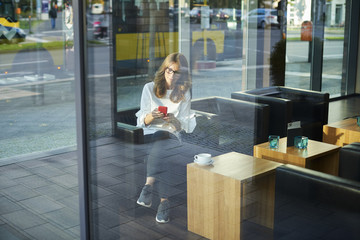 Confident woman using her mobile phone and text messaging