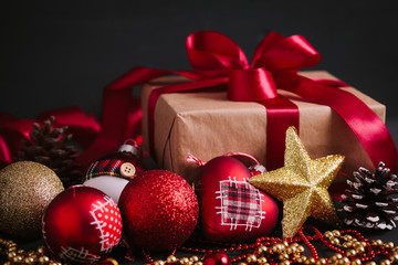 Composition with Christmas decorations  and gift on black background