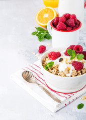 Oat granola with berries and yoghurt on light gray background. Copy space. Healthy breakfast concept.
