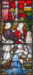 Fototapeta na wymiar LONDON, GREAT BRITAIN - SEPTEMBER 19, 2017: The Raising of Jairus Daughter on the stained glass in St Mary Abbot's church on Kensington High Street.