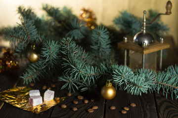 Coffee grinder, coffee beans and Christmas tree branch on a wooden table