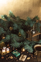 Coffee grinder, coffee beans and Christmas tree branch on a wooden table