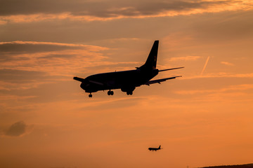 Two airplanes landing at sunset