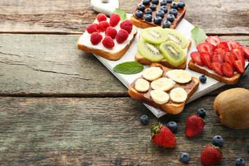 Toasts bread with berries on wooden table